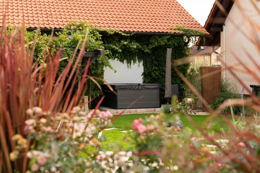 View through grasses and flowering plants towards the covered garden area