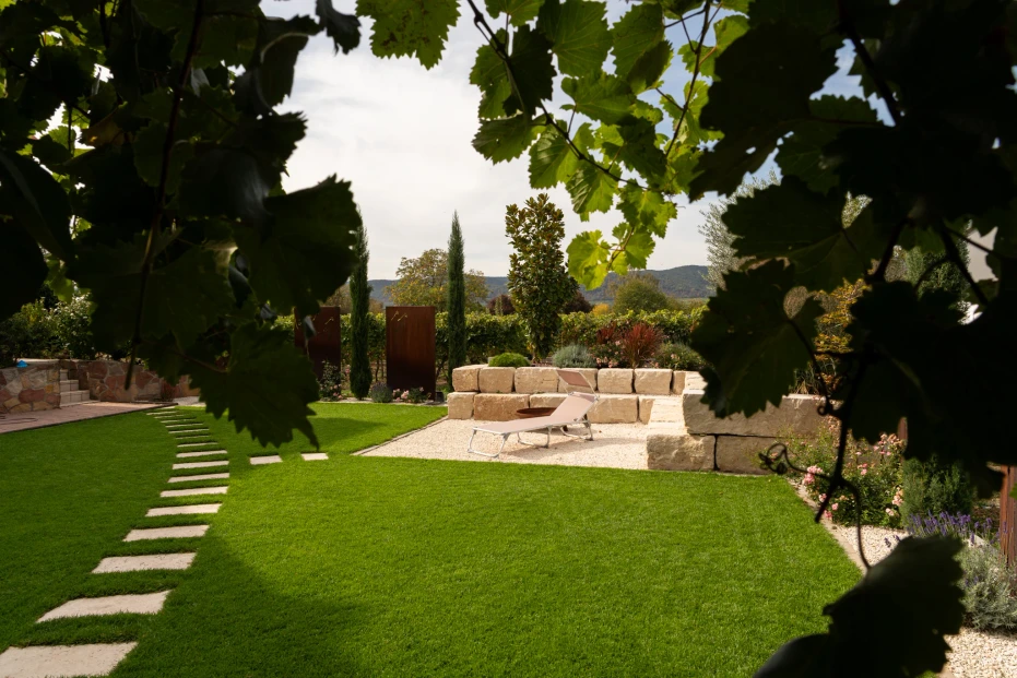 View through the planting towards stepping stones in the lawn and the gravel area