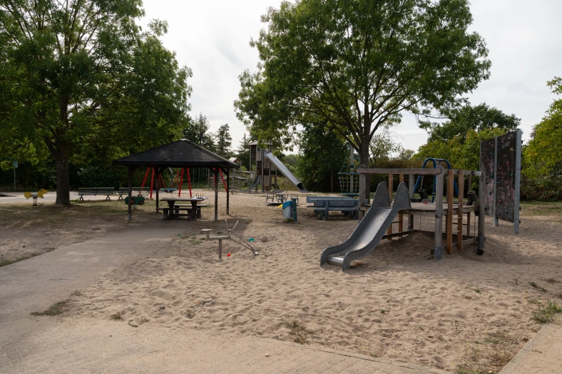 Spielplatz unmittelbar neben dem Wohnquartier Erpolzheim mit Rutschen, Schaukeln, Sandfläche und überdachtem Sitzbereich