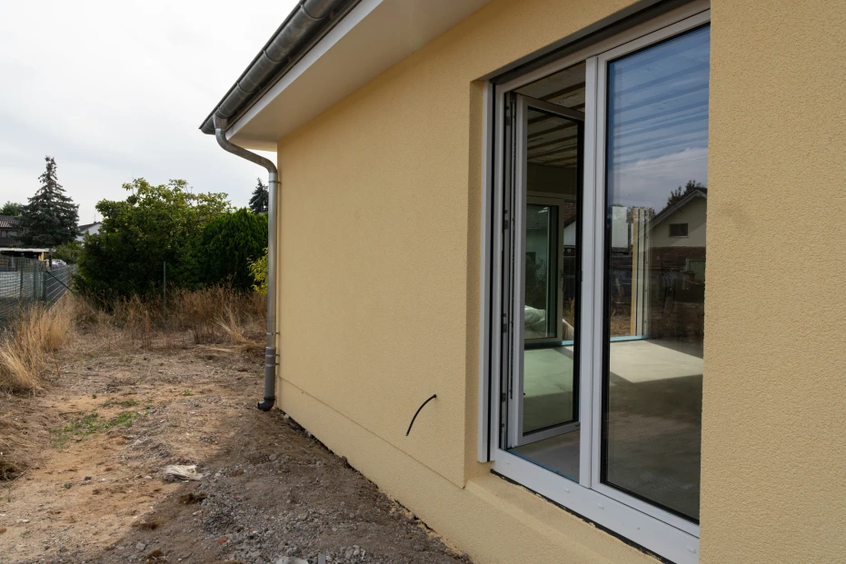 Geöffnete bodentiefe Fenstertür mit Blick vom Garten in den Innenraum