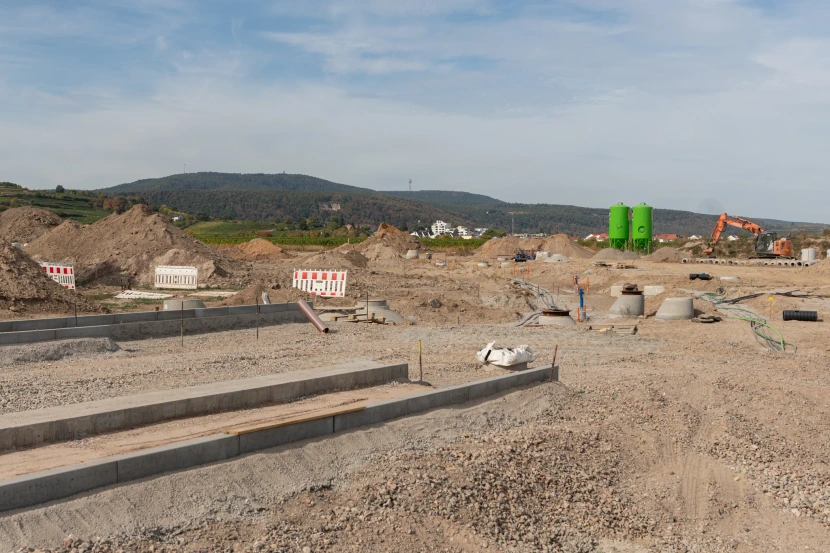 Kerbs, exposed access chambers and construction machinery with vineyards near Wachenheim in the background