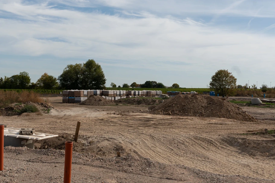 Open building plots with soil heaps, pipes and stacked materials at the new development in Wachenheim