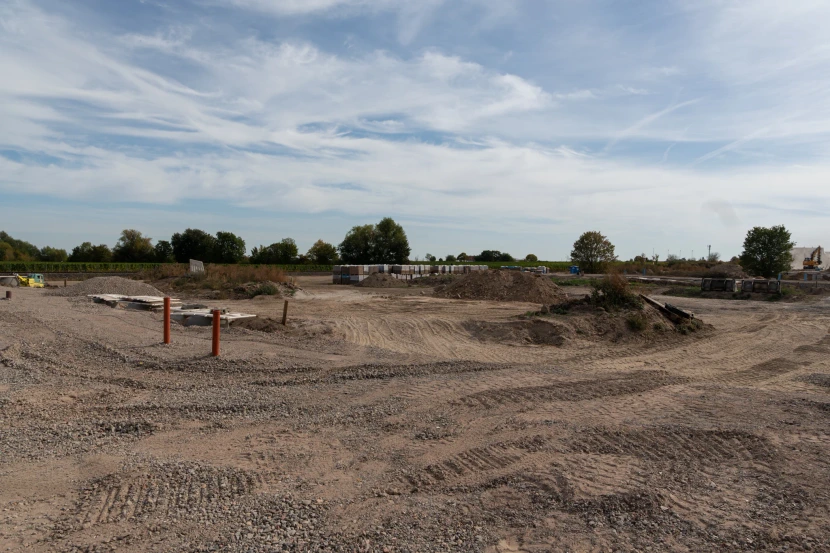 Wide view of the new development with a construction road, gravel surfaces and neighbouring vineyards